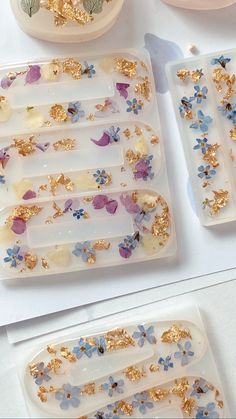 three trays with gold and blue flowers on them