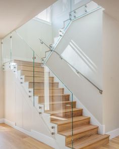 a staircase with glass railing and wooden steps