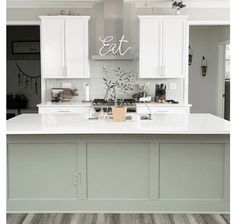 a kitchen with white cabinets and an island