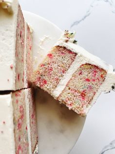 two slices of cake on a plate with white frosting and sprinkles