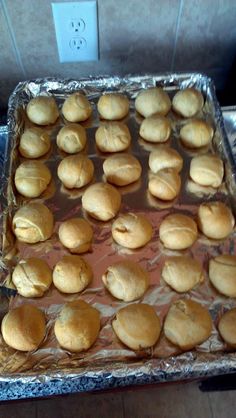 bread rolls sitting on top of tin foil in an oven, ready to go into the oven