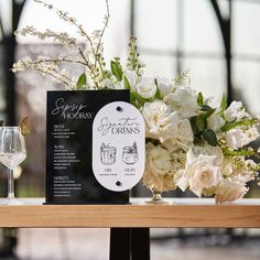 white flowers and greenery are on display at the reception table for guests to enjoy