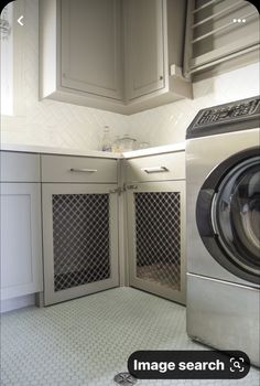 a washer and dryer in a small room with white cabinets on the walls