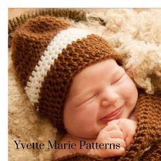 a newborn baby wearing a brown and white knitted hat is smiling at the camera