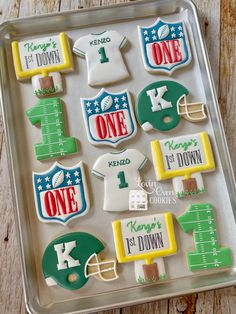 decorated cookies in the shape of football jerseys on a cookie sheet with words and numbers