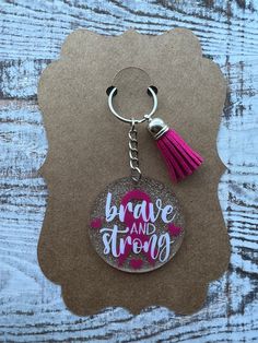 a keychain with the words brave and strong on it