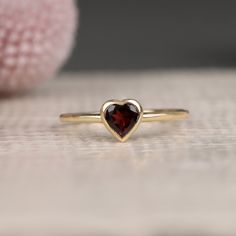 Ashly Follow your heart and it will lead you to our gold rings. This red heart ring has a beautiful heart shape cut and would make the perfect gift for her. Available in Yellow Gold, White Gold, and Rose Gold. - Handmade - Solid Gold- Natural Garnet- Total Garnet Carat Weight: .48 ctw- Bezel Setting Size: 7.5 mm- Ring Band: 1.4 mm All pieces come beautifully boxed in suede pouches you can always use (which really comes in handy when traveling!) Gold Rings Heart, Dainty Garnet Ring, Garnet Heart Ring, Vintage Promise Rings, Red Heart Ring, Promise Ring Gold, Girls Rings, Gold Garnet Ring, Golden Rings