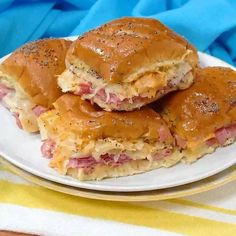 three ham and cheese sliders on a white plate