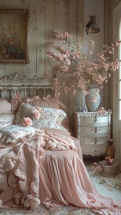 a bed with pink sheets and pillows in a room next to a painting on the wall