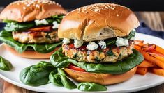 two chicken burgers with lettuce, tomato and cheese on a white plate