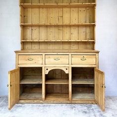 an old wooden dresser with two drawers and cupboards on the bottom, one door open