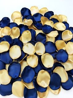 a pile of blue and gold petals on a white surface