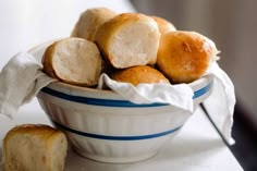 a bowl filled with rolls sitting on top of a table