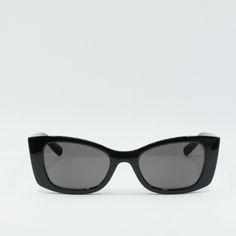 Step out in style with these Saint Laurent SL593 001 Black/Black sunglasses from OSSA FRAMES. Crafted from high-quality acetate, these designer frames are a must-have accessory for any fashionista. The sleek black frame and lens colors exude sophistication and elegance, making them a versatile choice for any outfit or occasion.  The cat-eye style of these sunglasses adds a touch of glamour and femininity to your look, while the 52mm lens width provides ample coverage and protection from the sun' Designer Frames, Black Sunglasses, Frame Design, Black Frame, Cat Eye, Timeless Elegance, Saint Laurent, Sleek, Sunglasses