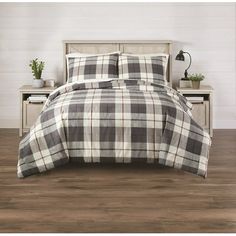 a bed with a plaid comforter and pillows