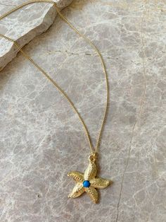 Nautical yet nice with this starfish charm necklace. Choose Turquoise or Lapis cabochon accent. Dimensions: Starfish is 1", 4mm cabochon, 18" Chain Materials: Pewter, Steel, 18k Gold Plating, Turquoise, Lapis Ships in a branded jewelry pouch and box, perfect for gift giving! Yellow Gold Starfish Necklace As Gift, Turquoise Jewelry With Starfish Charm As Gift, Turquoise Jewelry With Starfish Charm For Gift, Turquoise Necklace With Starfish Charm For Gift, Turquoise Necklace With Starfish Charm As Gift, Blue Quartz, Light Turquoise, Jewelry Pouch, Starfish