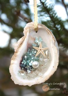 an ornament hanging from a tree with sea glass and starfish on it