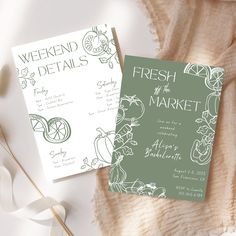 two green and white wedding cards on top of a blanket next to a flower arrangement