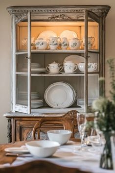 an old china cabinet with dishes on it