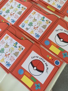 several red cards with pictures of pokemons on them sitting on a table in front of each other