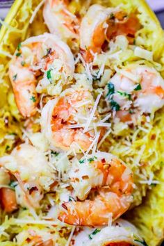 shrimp and pasta with parmesan cheese is served in a yellow dish on a plate