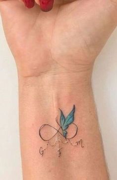 a small wrist tattoo with a blue butterfly on it's left arm and the word go