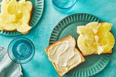 two pieces of bread with peanut butter and pineapple on them sitting next to glasses