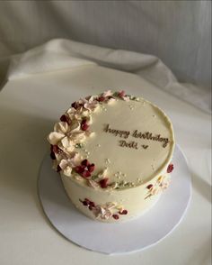 a birthday cake with white frosting and flowers on it