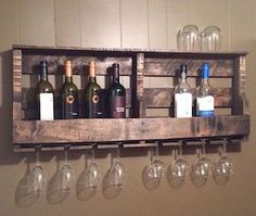 several wine glasses and bottles are hanging on a wooden rack with wine glasses in it