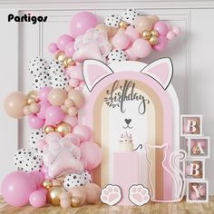 a pink and gold baby shower party with balloons, streamers, cat balloon arch