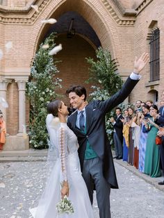 a bride and groom are throwing confetti in the air