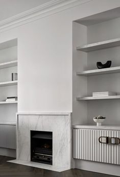 an empty room with a fireplace and shelves