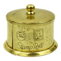 a gold colored stamp holder with a stamp on the front and bottom that says stamp roll