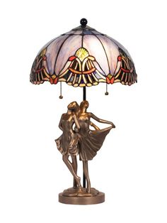 a table lamp with a woman holding a man's head on top of it