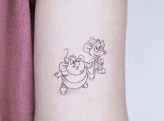 a tattoo on the arm of a woman with a cartoon character drawn on it's side