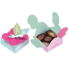 two boxes filled with chocolates in the shape of mickey mouse ears and a pink flower