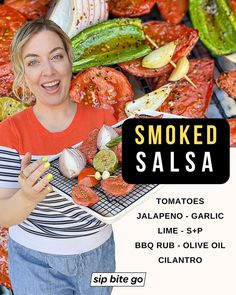 a woman holding a tray of food in front of a pile of grilled vegetables