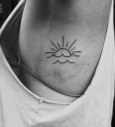 a woman's chest with the sun and clouds tattoo on her left side ribcage