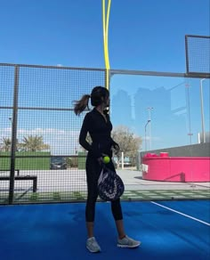 a woman holding a tennis racquet on top of a tennis court with a ball in her hand