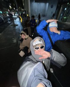 a man in a blue jacket and sunglasses doing a trick on his skateboard at night