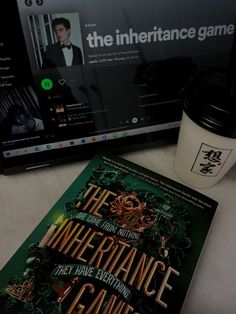 there is a coffee cup and book on the table next to the computer screen that shows the interface game