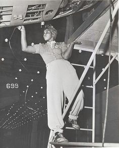 an old black and white photo of a woman climbing up the stairs on a ship