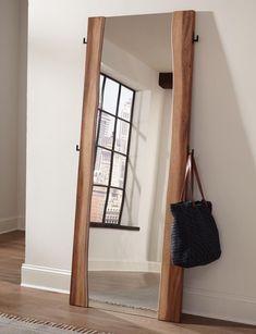 a large mirror sitting on the side of a wall next to a purse and handbag