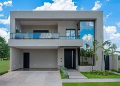 a modern house with two balconies on the second floor