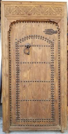 an old wooden door with metal studs on it