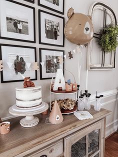 a table with cake, balloons and pictures on the wall