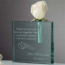 a white rose sitting on top of a glass block