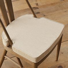 a close up of a wooden chair with a cushion on it