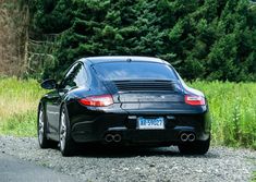 a black porsche parked on the side of a road