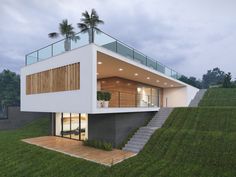 a modern house with glass balconies on the roof and stairs leading up to it